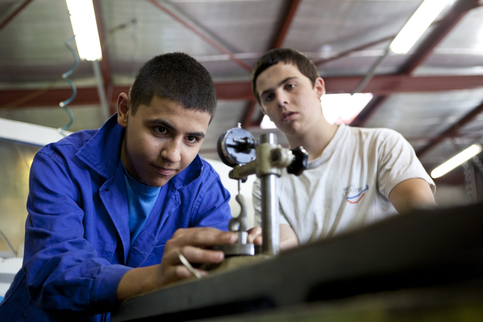 Deux jeunes au travail dans l'atelier d'une école de production