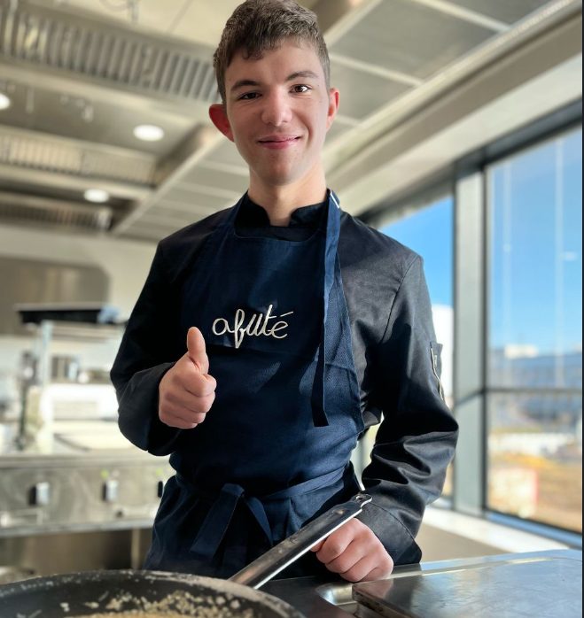 Jeune apprenti souriant en cuisine dans une structure d'insertion