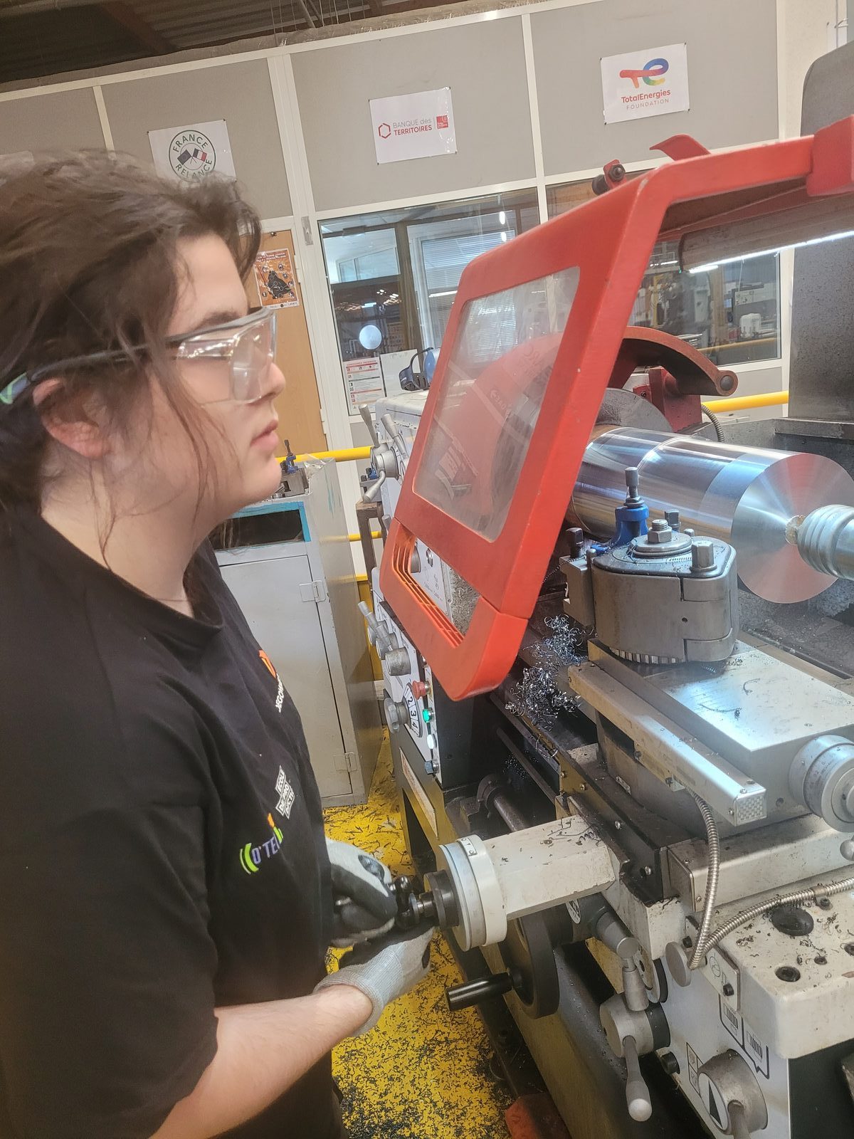 Apprentie au tour dans l'atelier d'une École de Production